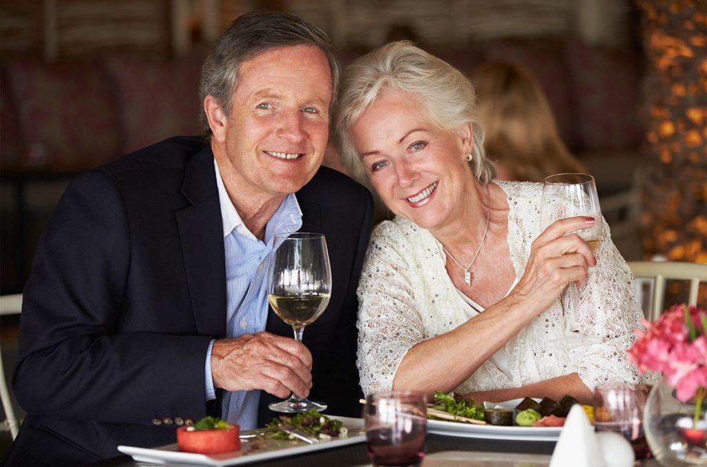 portrait of smiling couple eating a complimentary gourmet meal at one of our educational seminars holland oh